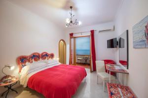 a bedroom with a red bed with a red blanket at Il Giardino Dei Limoni in Praiano