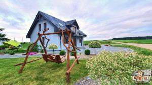 a swing in front of a small house at Agrosielanka in Lipnica