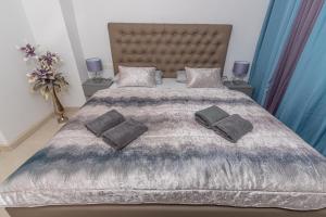una camera da letto con un grande letto con due cuscini sopra di Apartmani Kecman a Crikvenica