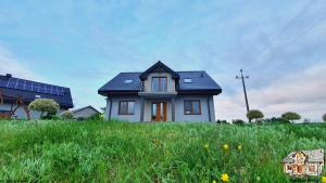 uma pequena casa numa colina com relva verde em Agrosielanka em Lipnica