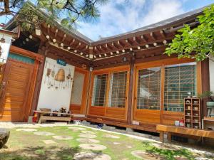 dom z drewnianymi drzwiami i patio w obiekcie The Blue Cradle w mieście Jeonju