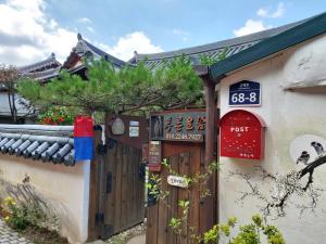 ein Gebäude mit einem Tor und Schildern darauf in der Unterkunft The Blue Cradle in Jeonju