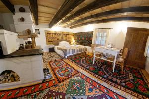 バマにあるCasa Povestilor din Bucovinaのベッドルーム1室(ベッド1台、テーブル、ラグ付)