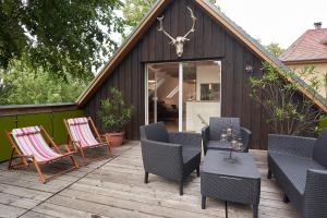 a wooden deck with chairs and a table and a building at Heuboden in Mellenthin +6 photos