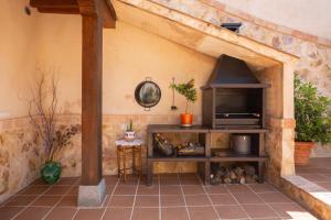 an outdoor kitchen with a stone wall with a pizza oven at Casa Rural Almenas del Cid in Almonacid de Toledo
