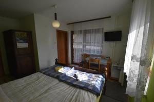 Schlafzimmer mit einem Bett, einem Tisch und einem Fenster in der Unterkunft Guest House Žnidar in Bohinj