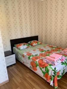 アドレルにあるRuzanna Innのベッドルーム1室(花柄の掛け布団付きのベッド1台付)