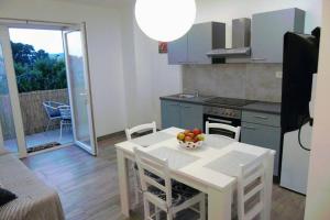 Una cocina con una mesa con un bol de fruta encima. en Apartman Greta Sukošan, en Sukošan