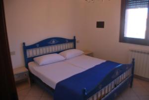 een blauw bed met 2 kussens in een slaapkamer bij Acquasmeralda appartamento 01 in Rosolina Mare