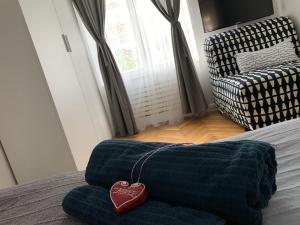 łóżko z niebieskim kocem z naszyjnikiem na sercu w obiekcie Apartmani SB 42 w Zagrzebiu