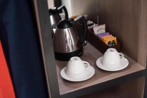 a tea pot and saucers on a shelf in a hotel room at Oxford Hotel in London