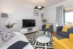 a living room with a couch and a tv at Captain's Apartment with Sea View in Kraljevica