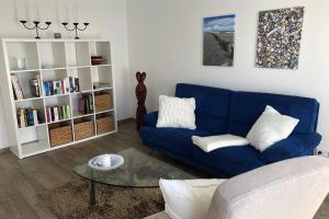 een woonkamer met een blauwe bank en een boekenplank bij Schöner (Ferien-) Wohnen in Bad Laer in Bad Laer