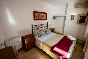 a bedroom with a bed and a dresser at Pension el Portillo in Córdoba