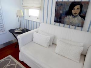 un sofá blanco en una sala de estar con una pintura en Am Eichholz Galerie & Art-Hotel, en Murnau am Staffelsee
