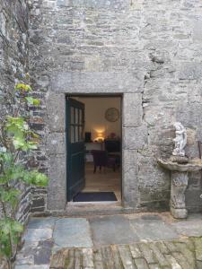 una puerta a un edificio de piedra con una puerta en Les Cottages du Château du Rozel, en Le Rozel