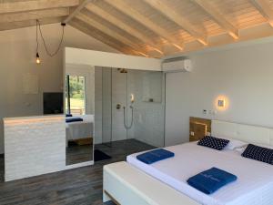 a bedroom with a large bed and a shower at Rokamare in Liapades