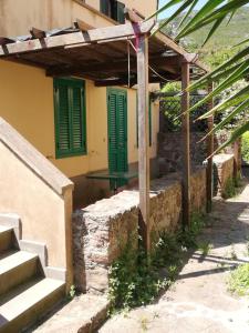 Porto Vecchio的住宿－Mia House，前面有绿色门和楼梯的建筑
