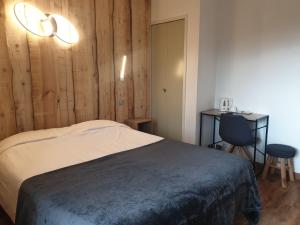 a bedroom with a bed and a desk and a chair at Hôtel Yaka in Les Angles