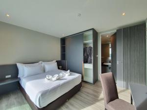 a bedroom with a large bed and a chair at GOOD DREAM PREMIER in Hat Yai
