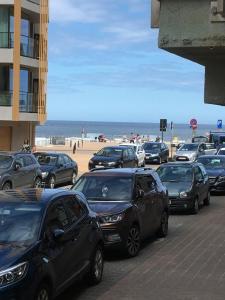 a parking lot with cars parked next to the beach at De Zandkorrel in Westende