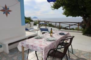 a table with a bottle of wine and chairs on a patio at casavictoria in Ponza
