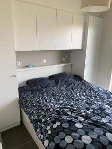 a bed in a small room with white cabinets at Karthuizer appartement in Nieuwpoort