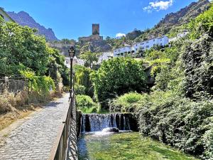 a small waterfall next to a river with a street light at VTAR San Isicio in Cazorla