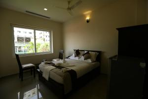 a bedroom with a large bed and a window at Le Noor in Ernakulam