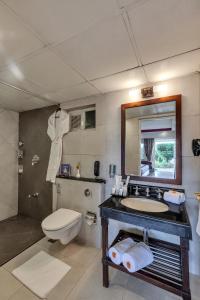 a bathroom with a sink and a toilet and a mirror at Club Mahindra Derby Green, Ooty in Ooty