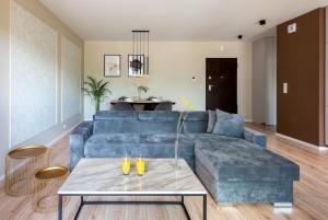 a living room with a blue couch and a table at apartamenty-wroc River Point in Wrocław