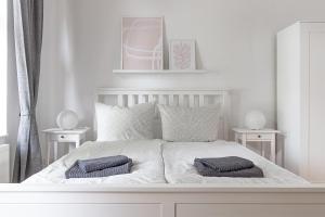 a bedroom with a white bed with two pillows on it at Ferienwohnungen Quedlinburg im Harz in Quedlinburg
