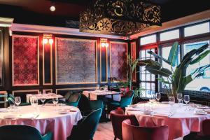 a restaurant with tables and chairs and windows at Hotel & Restaurant Marina Palamós in Palamós