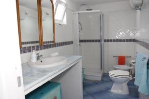 bagno con lavandino, servizi igienici e specchio di casavictoria a Ponza