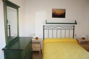a bedroom with a yellow bed and a dresser at Estrella de Mar in Los Urrutias