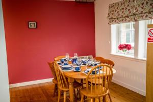 
a dining room table and chairs in a room at Tigh Eilidh Cottage in St. Andrews
