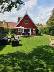a red barn with couches and chairs in a yard at Lekker Plekje Achterhoek in Lievelde