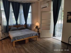 a bedroom with a bed with blue curtains and a window at huge apartment near to Bahai Garden in Haifa