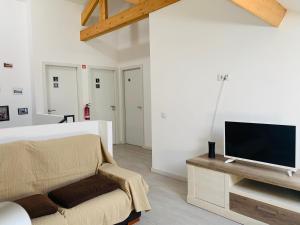 a living room with a bed and a tv on a table at Campanhã Boutique Station in Porto