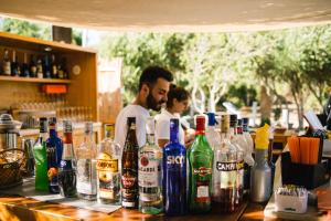 a man standing behind a bar with bottles of alcohol at Le Ville Le Saline in Palau