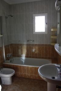 een badkamer met een bad, een toilet en een wastafel bij Estrella de Mar in Los Urrutias