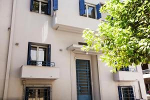 biały budynek z niebieskimi oknami i drzwiami w obiekcie Bentzi...Boutique Apartment 6, Superior Suite for 4 Guests w Atenach