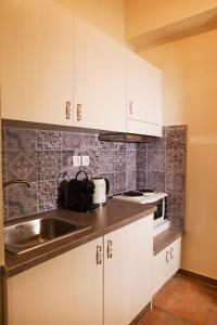 kuchnia z białymi szafkami i zlewem w obiekcie Bentzi...Boutique Apartment 6, Superior Suite for 4 Guests w Atenach