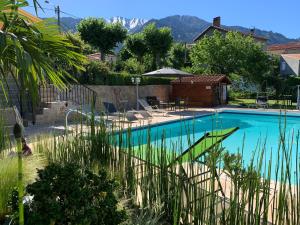 a swimming pool with mountains in the background at VILLA ROMAGA in Vernet-les-Bains