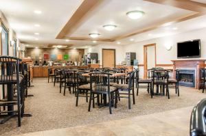 a restaurant with tables and chairs and a fireplace at Comfort Inn in Dickinson