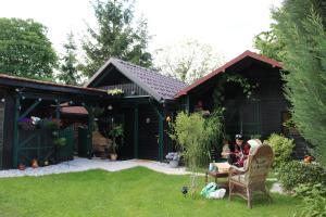森克的住宿－Frenk cottage 5 KM FROM THE AIRPORT-free transportation，坐在花园里椅子上的女人