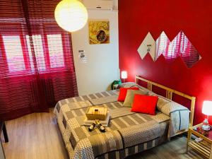 マテーラにあるTesta o Croce Casa Vacanzeの赤い壁のベッドルーム1室(ベッド2台付)