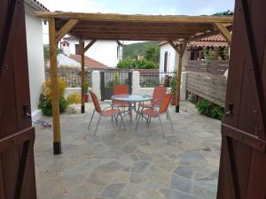 un patio con mesa y sillas bajo una pérgola en Avra House in Argalasti, en Argalasti