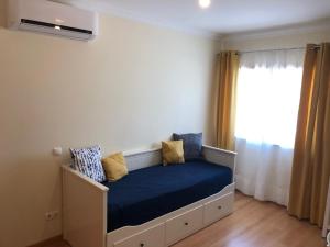 um quarto com uma cama com lençóis azuis e uma janela em Montenegro Dreams em Faro