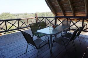 a table and four chairs on a deck at Giraffe plains in Marloth Park